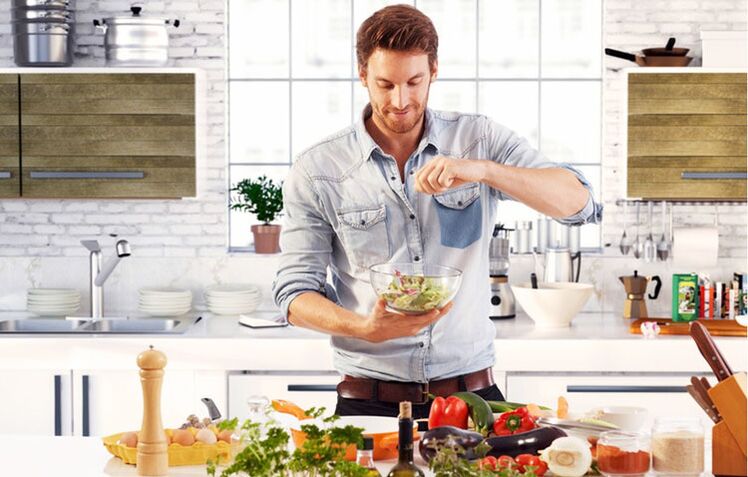 homem prepara salada de legumes para aumentar a potência